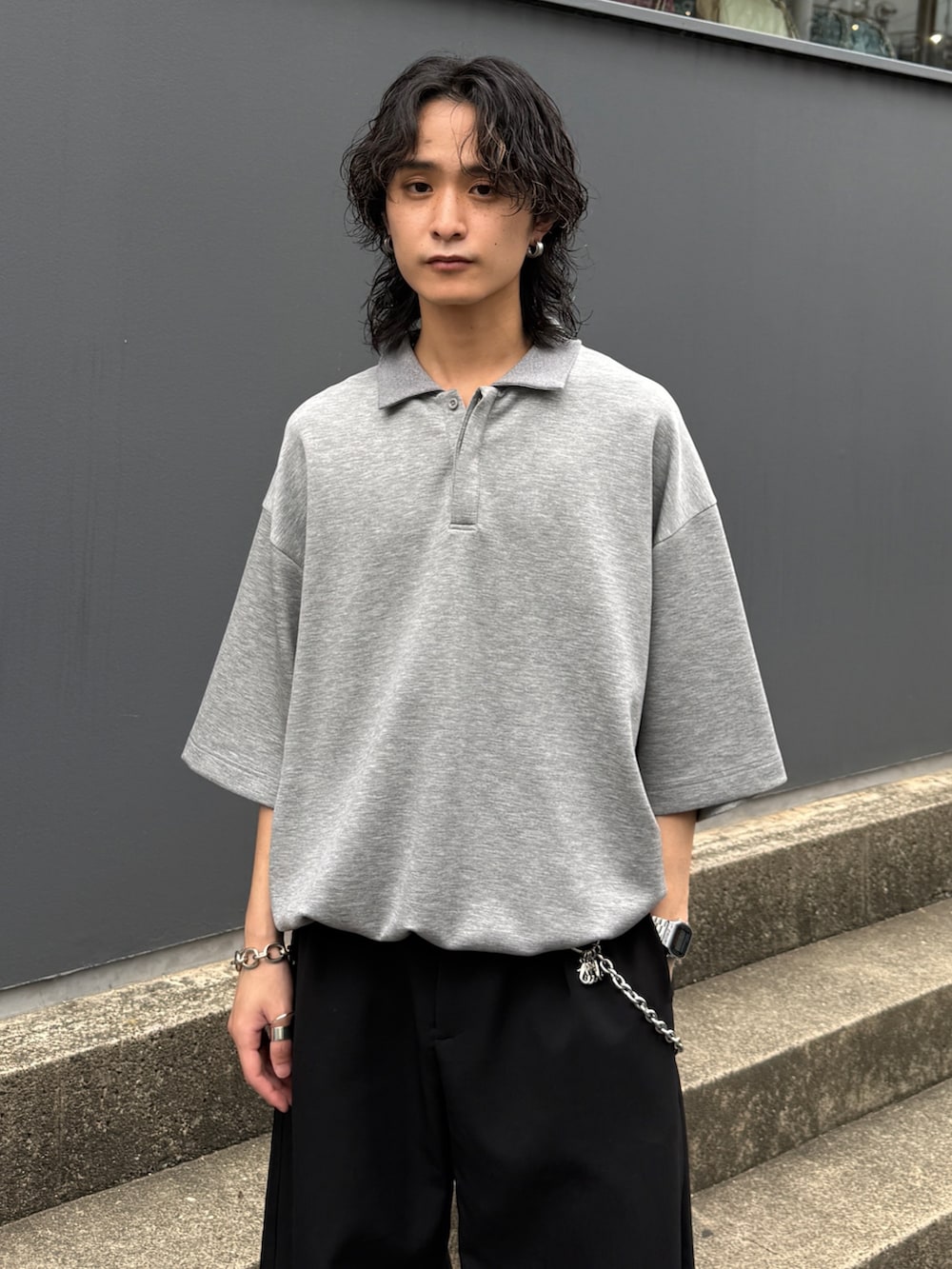 グレー系のTシャツ/カットソー、ブラック系のスラックス、シルバー系のウォレットチェーンを着用したメンズの夏コーディネートの4枚目の写真