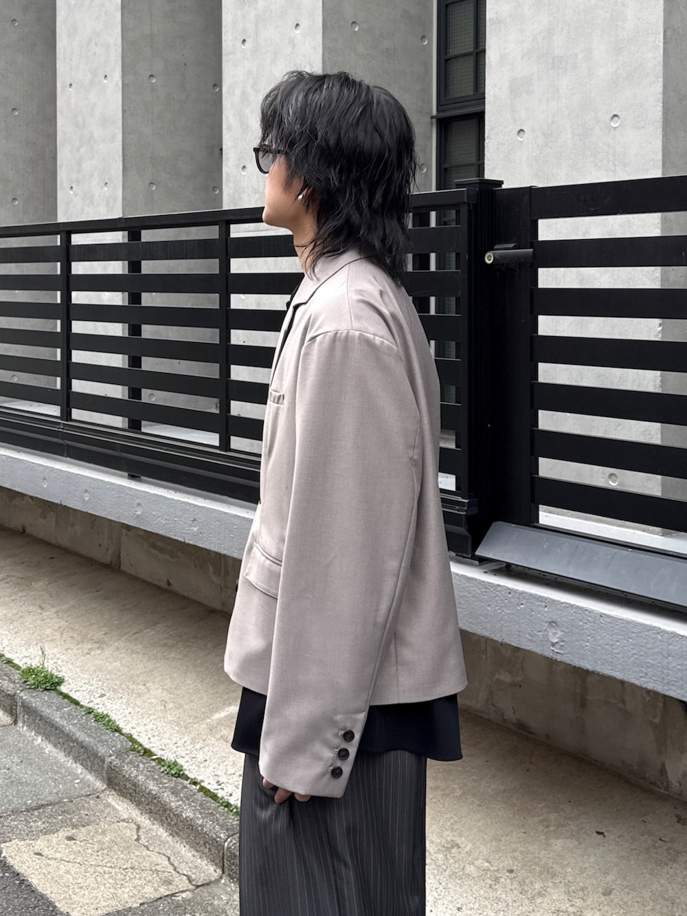 グレー系のスラックス、グレー系のテーラードジャケット、ブラック系のシャツ/ブラウスを着用したメンズの春コーディネートの4枚目の写真