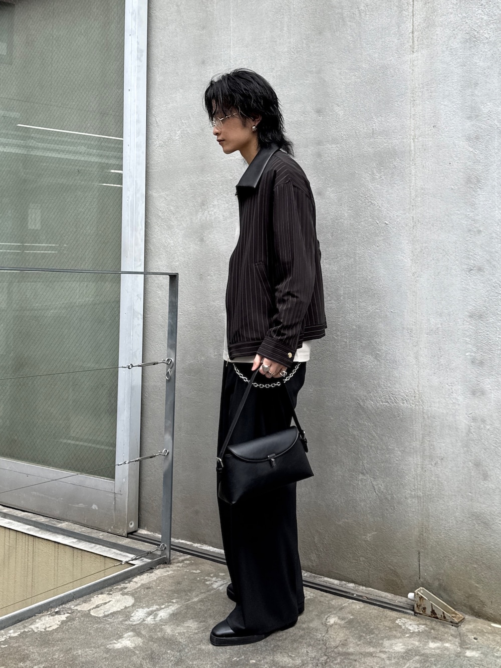 ブラック系のその他パンツ、ブラック系のハンドバッグ、グレー系のTシャツ/カットソーを着用したメンズの春コーディネートの2枚目の写真