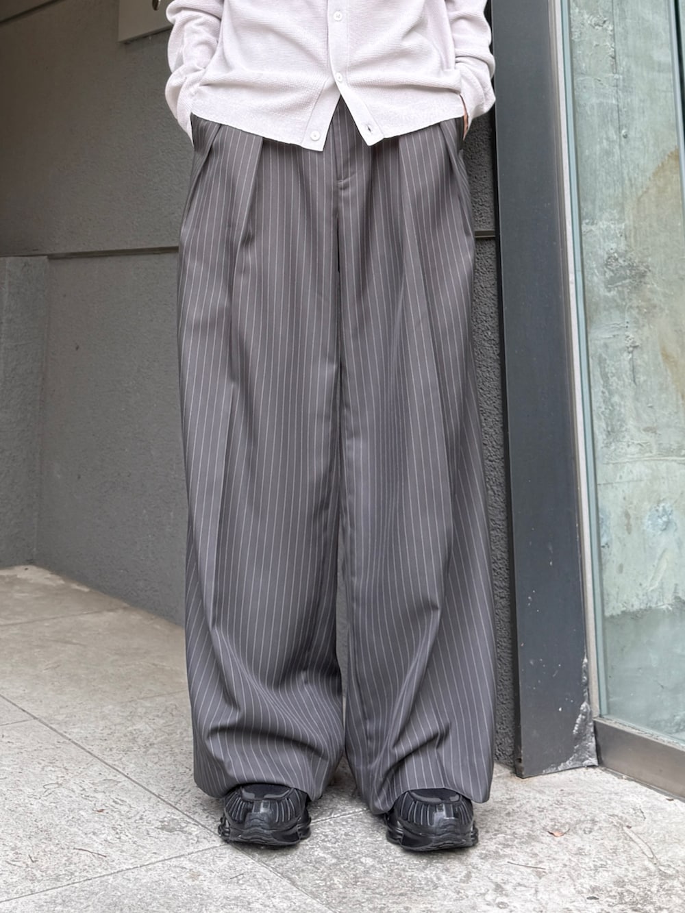 グレー系のスラックス、グレー系のシャツ/ブラウス、ブラック系のブルゾンを着用したメンズの夏コーディネートの9枚目の写真