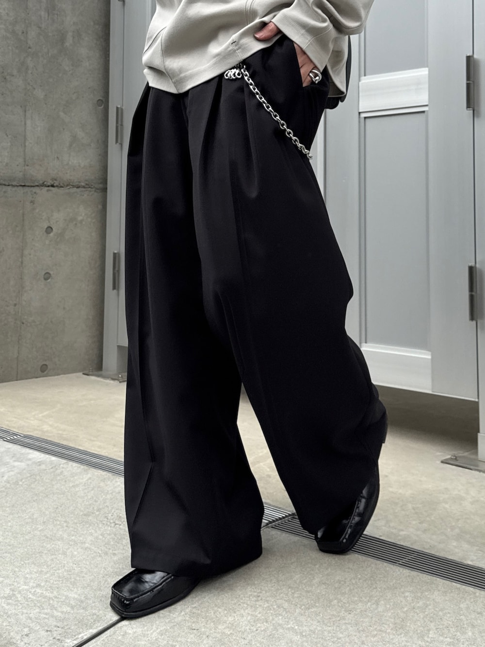 グレー系のTシャツ/カットソー、ブラック系のショルダーバッグ、ブラック系のスラックスを着用したメンズの春コーディネートの7枚目の写真