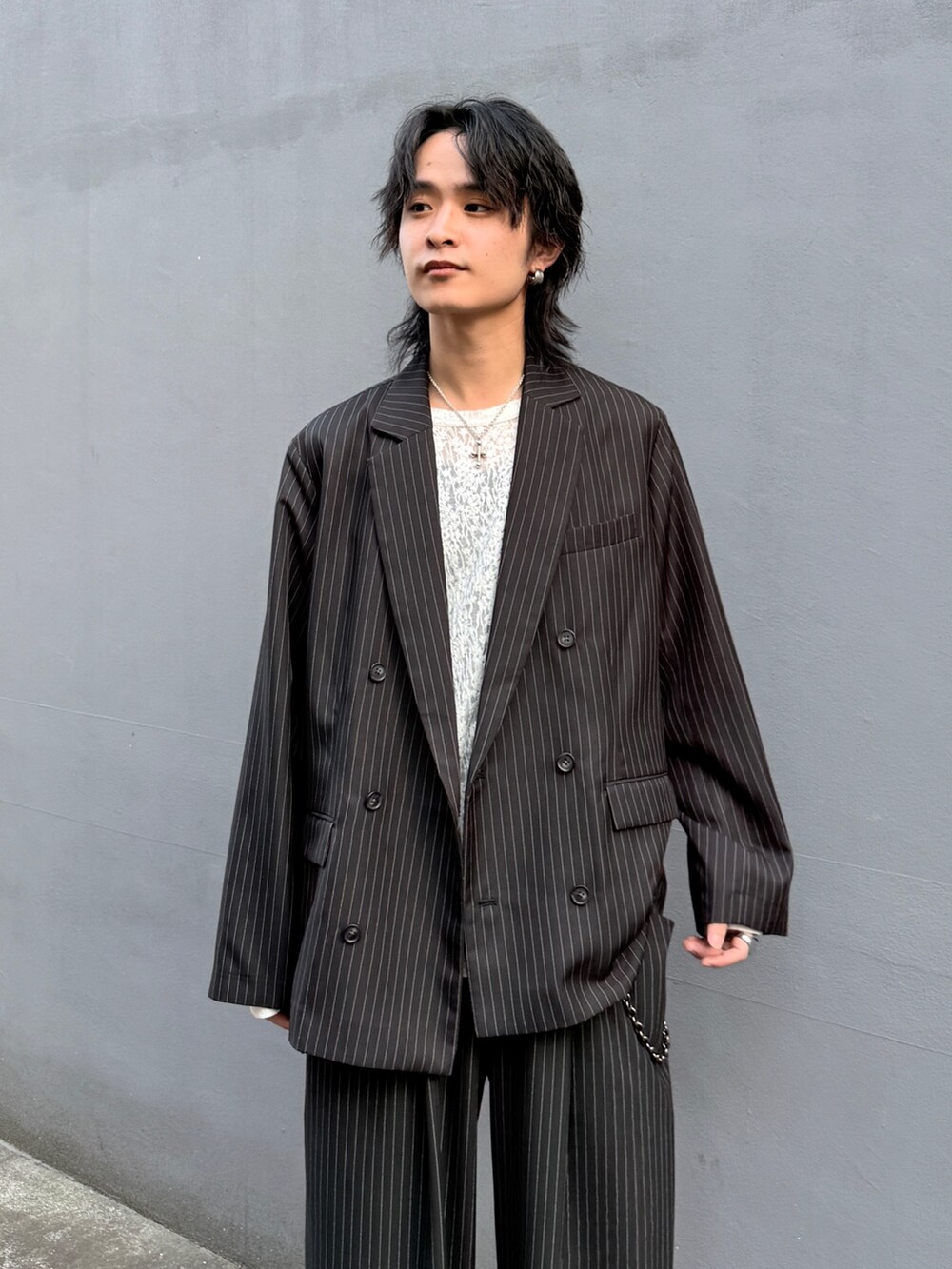 ブラック系のテーラードジャケット、ブラック系のスラックス、ホワイト系のTシャツ/カットソーを着用したメンズの春コーディネートの5枚目の写真