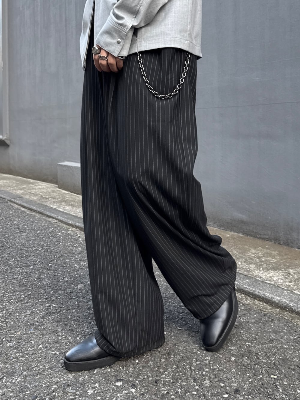 ブラック系のテーラードジャケット、グレー系のシャツ/ブラウス、ブラック系のスラックスを着用したメンズの春コーディネートの10枚目の写真