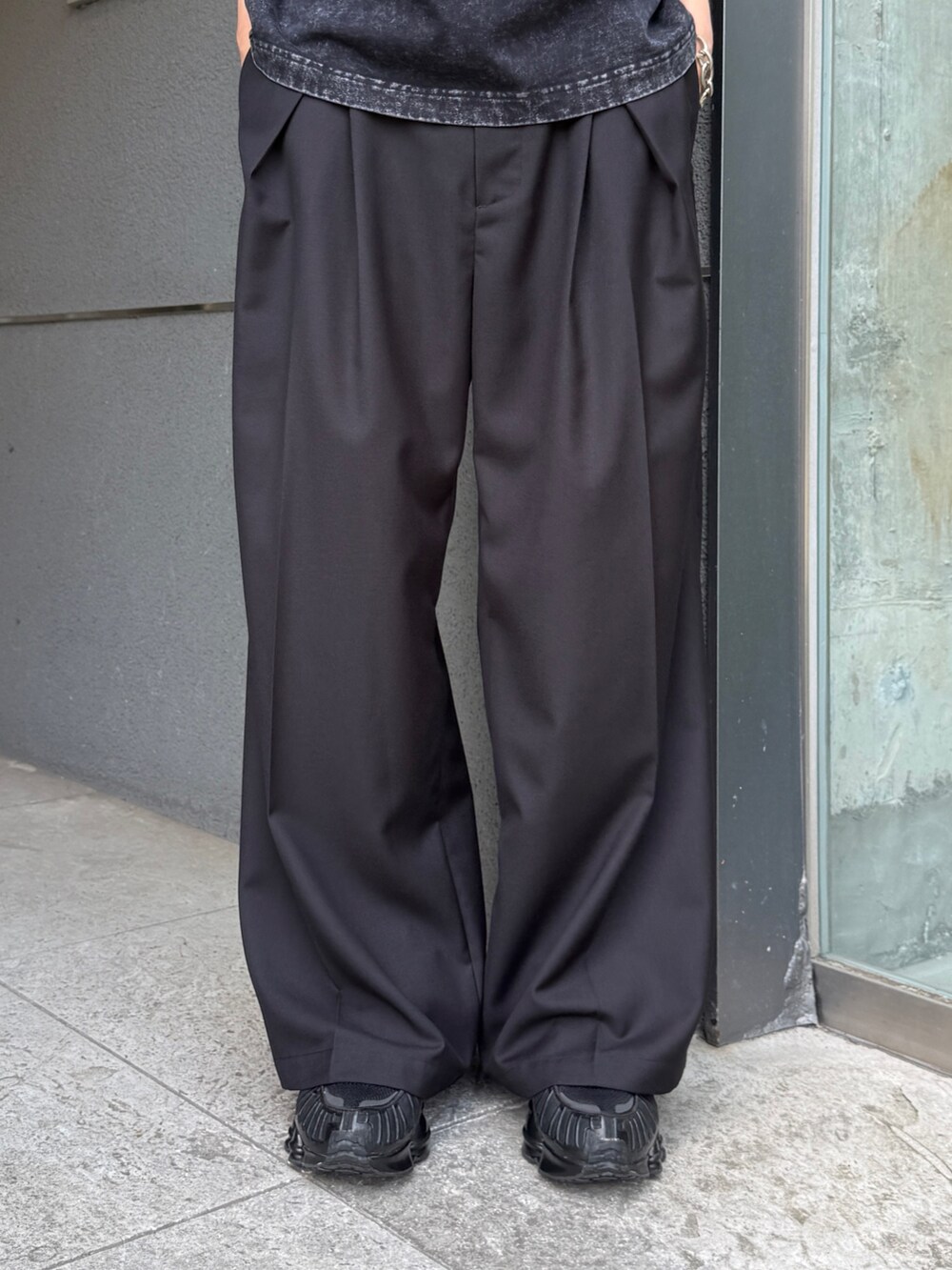 グレー系のTシャツ/カットソー、ブラック系のスラックスを着用したメンズの夏コーディネートの7枚目の写真