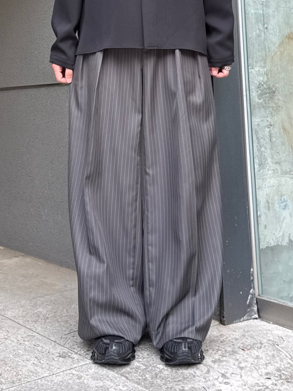 グレー系のスラックス、ブラック系のシャツ/ブラウスを着用したメンズの夏コーディネートの7枚目の写真