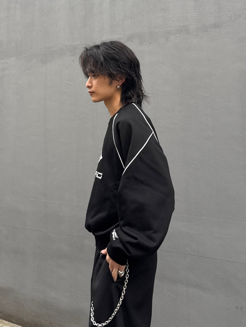 ブラック系のスウェット、ブラック系のスラックス、シルバー系のウォレットチェーンを着用したメンズの春コーディネートの5枚目の写真