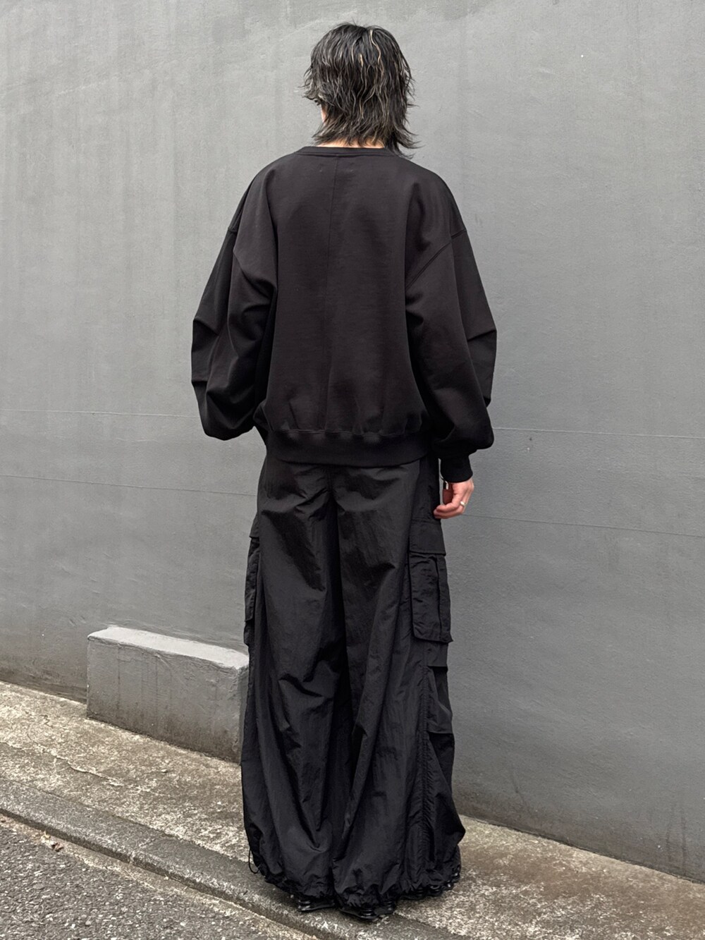 ブラック系のパーカー、ブラック系のカーゴパンツ、ブラック系のスウェットを着用したメンズの冬コーディネートの10枚目の写真