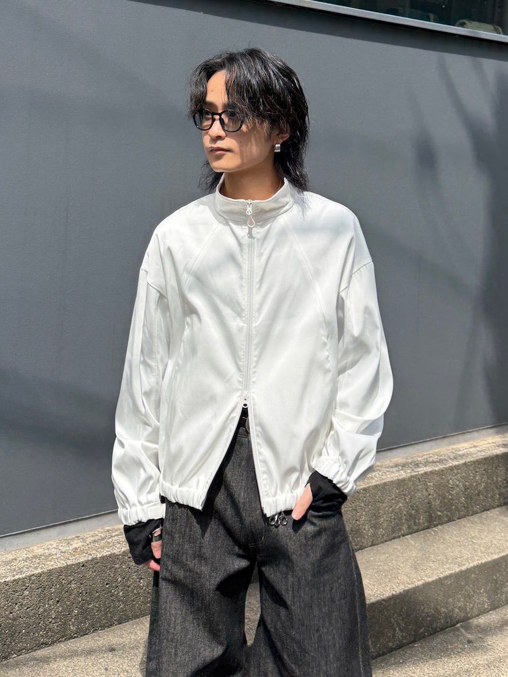 ホワイト系のブルゾン、ブラック系のTシャツ/カットソー、ブラック系のデニムパンツを着用したメンズの春コーディネートの4枚目の写真