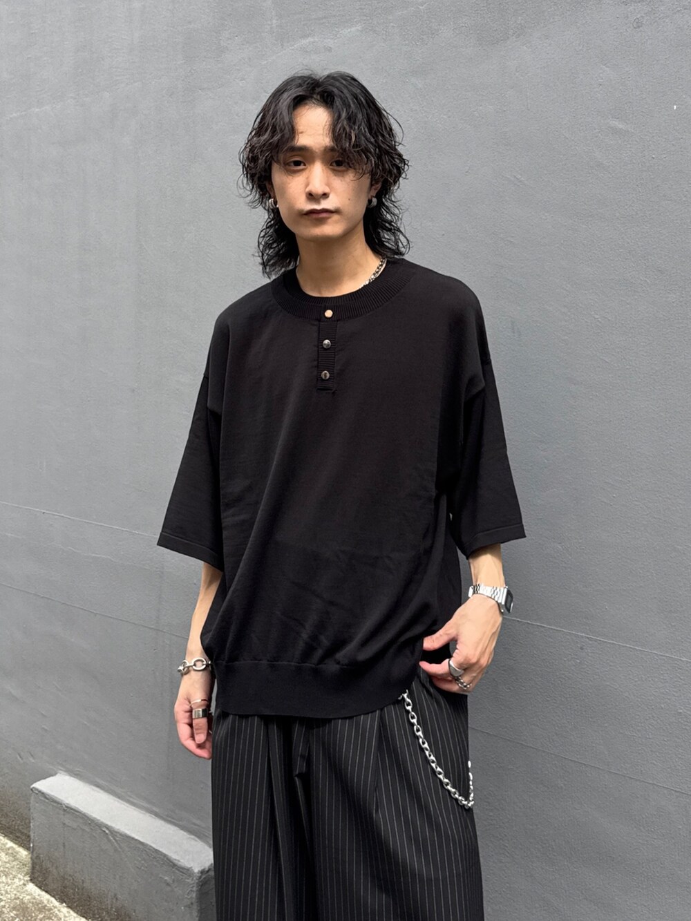ブラック系のTシャツ/カットソー、ブラック系のスラックス、シルバー系のウォレットチェーンを着用したメンズの夏コーディネートの4枚目の写真