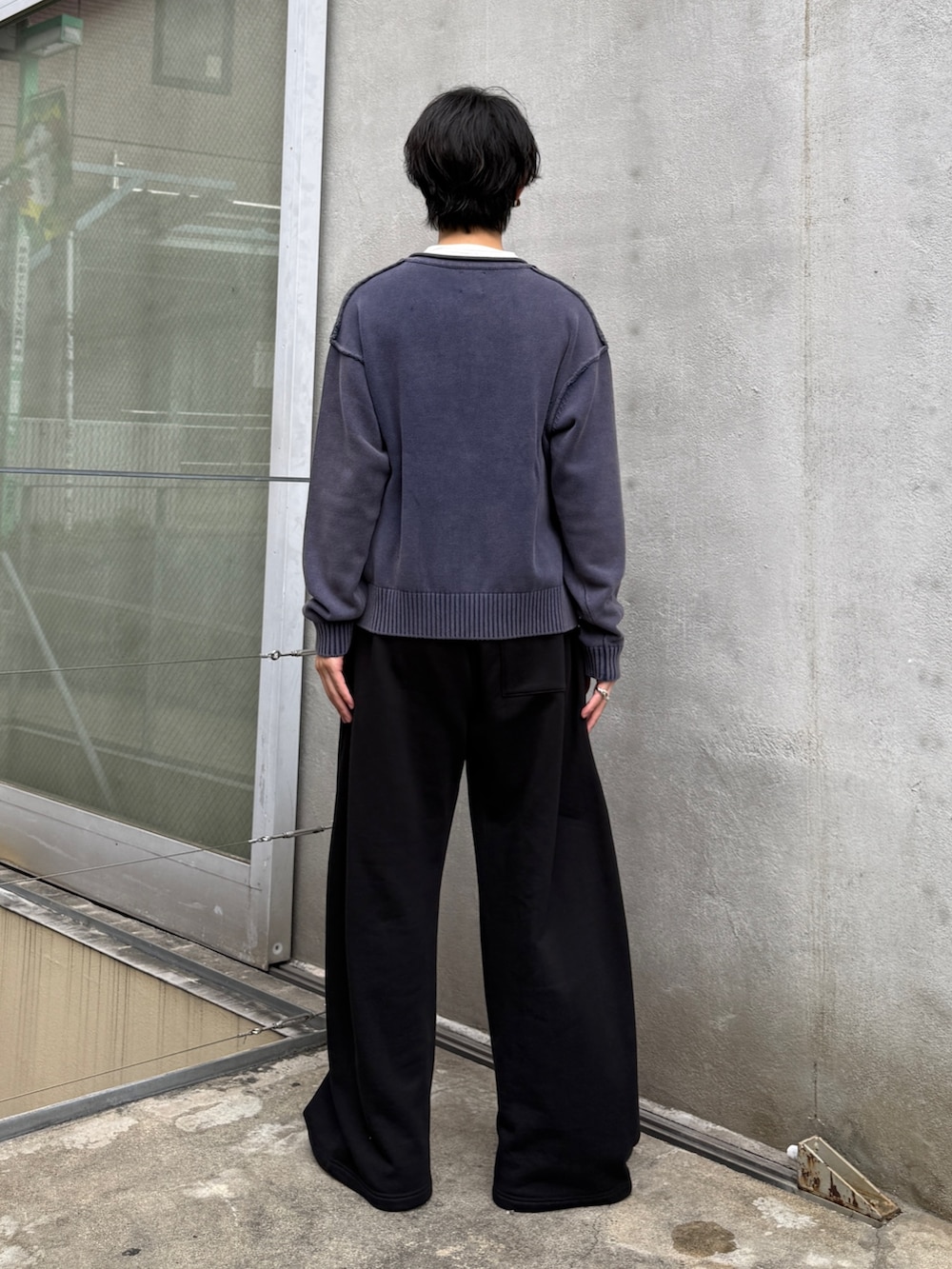 ブルー系のニット/セーター、ブラック系のスウェットパンツを着用したメンズの秋コーディネートの3枚目の写真