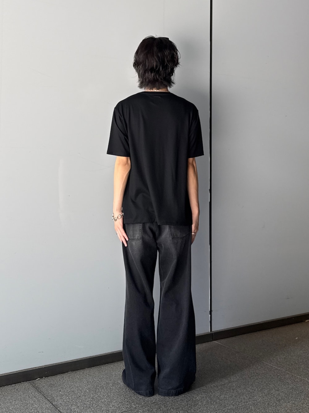 ブラック系のTシャツ/カットソー、ブラック系のデニムパンツを着用したメンズの夏コーディネートの3枚目の写真