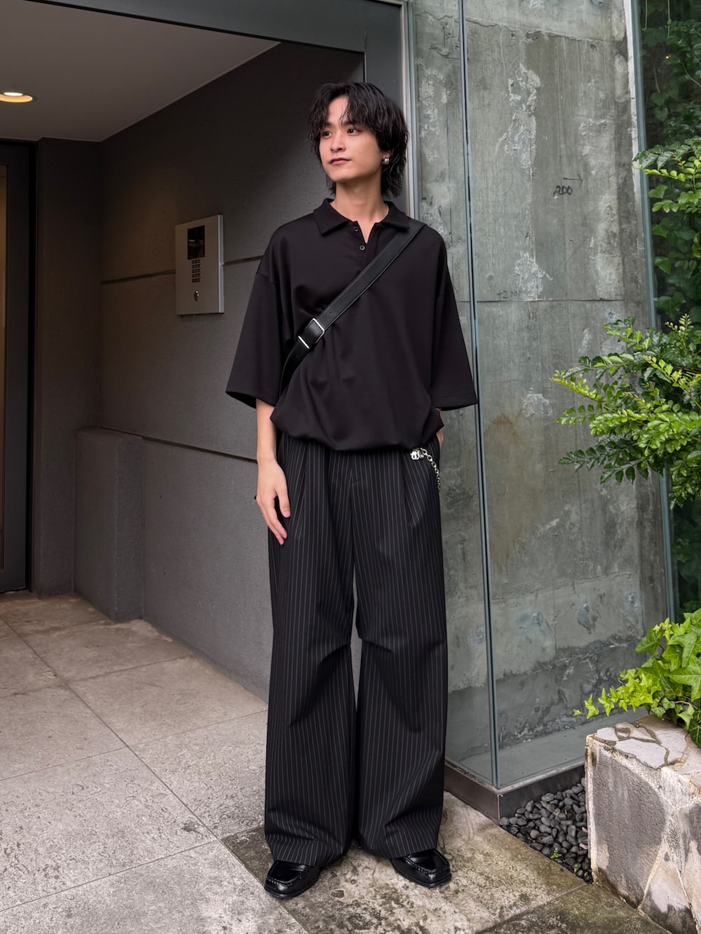 ブラック系のスラックス、ブラック系のTシャツ/カットソー、ブラック系のショルダーバッグを着用したメンズの夏コーディネートの2枚目の写真