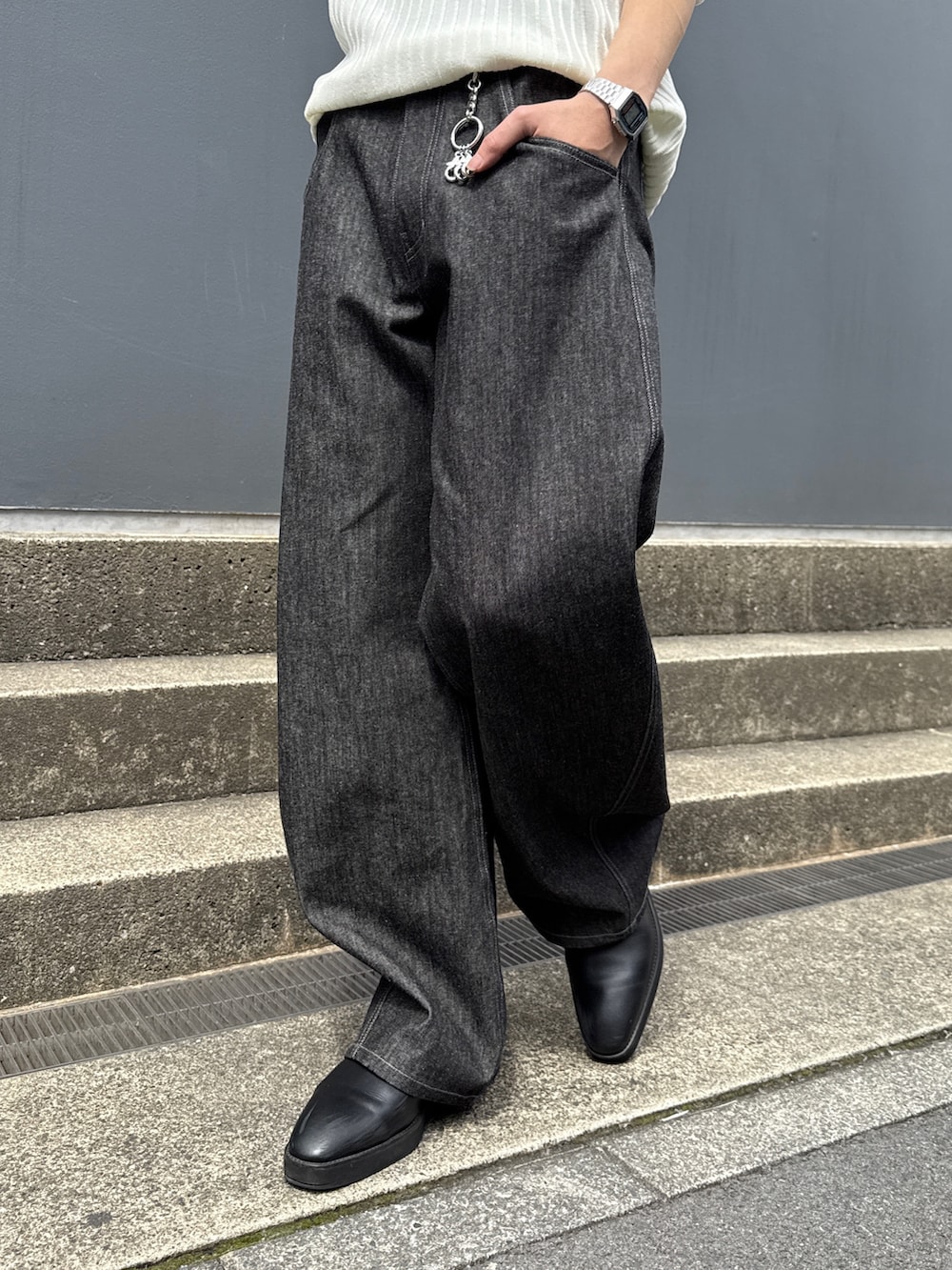 ブラック系のデニムパンツ、ブラック系のショルダーバッグ、ホワイト系のニット/セーターを着用したメンズの春コーディネートの10枚目の写真