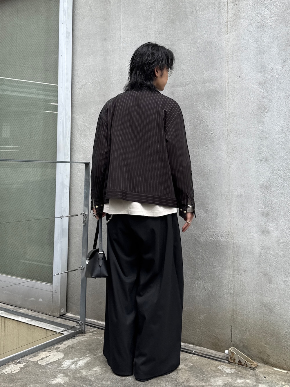 ブラック系のその他パンツ、ブラック系のハンドバッグ、グレー系のTシャツ/カットソーを着用したメンズの春コーディネートの3枚目の写真