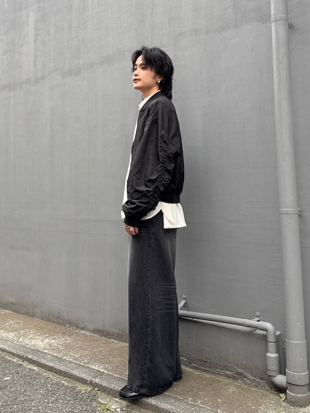 ブラック系のデニムパンツ、ホワイト系のシャツ/ブラウス、ブラック系のMA-1を着用したメンズの春コーディネートの2枚目の写真