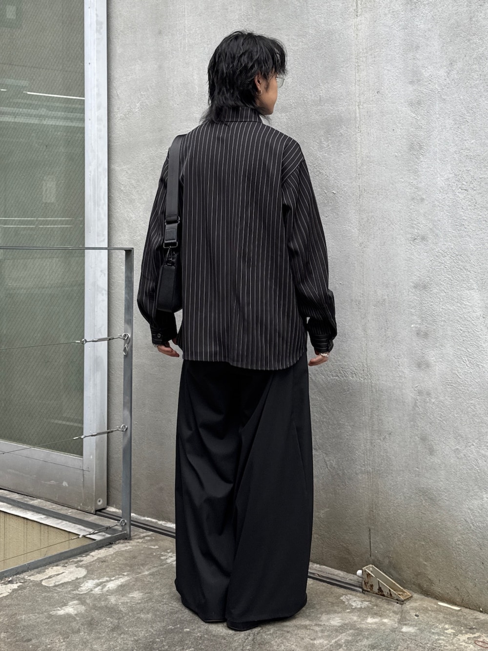 ブラック系のその他パンツ、ブラック系のショルダーバッグ、ブラック系のシャツ/ブラウスを着用したメンズの春コーディネートの3枚目の写真