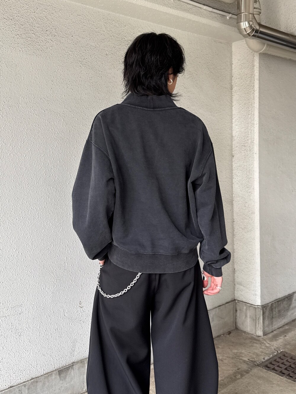 ブラック系のスウェット、ブラック系のスラックス、シルバー系のネックレスを着用したメンズの春コーディネートの6枚目の写真