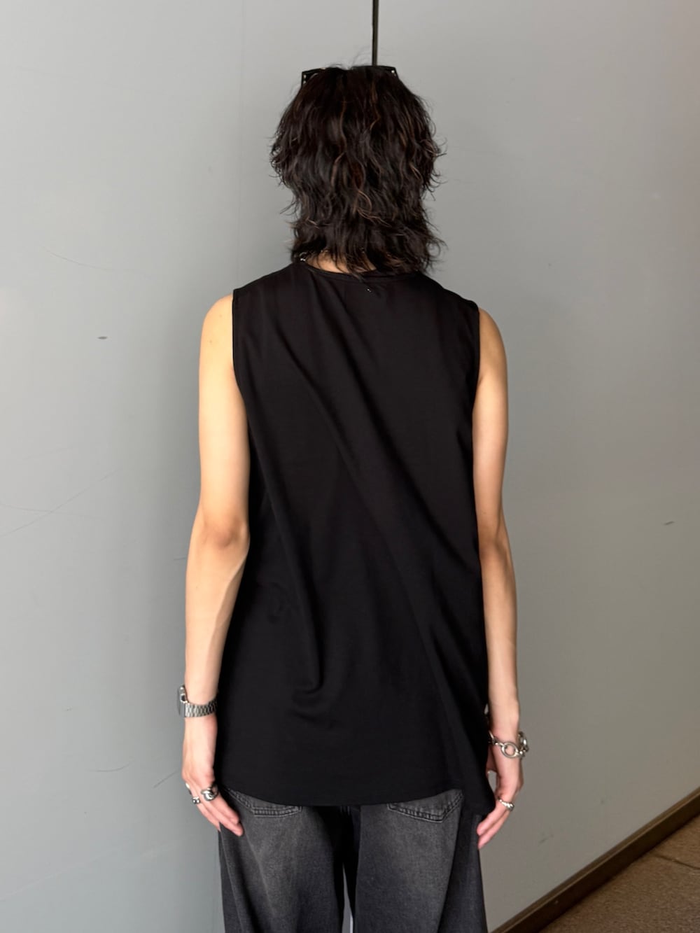ブラック系のデニムパンツ、ブラック系のタンクトップを着用したメンズの夏コーディネートの6枚目の写真