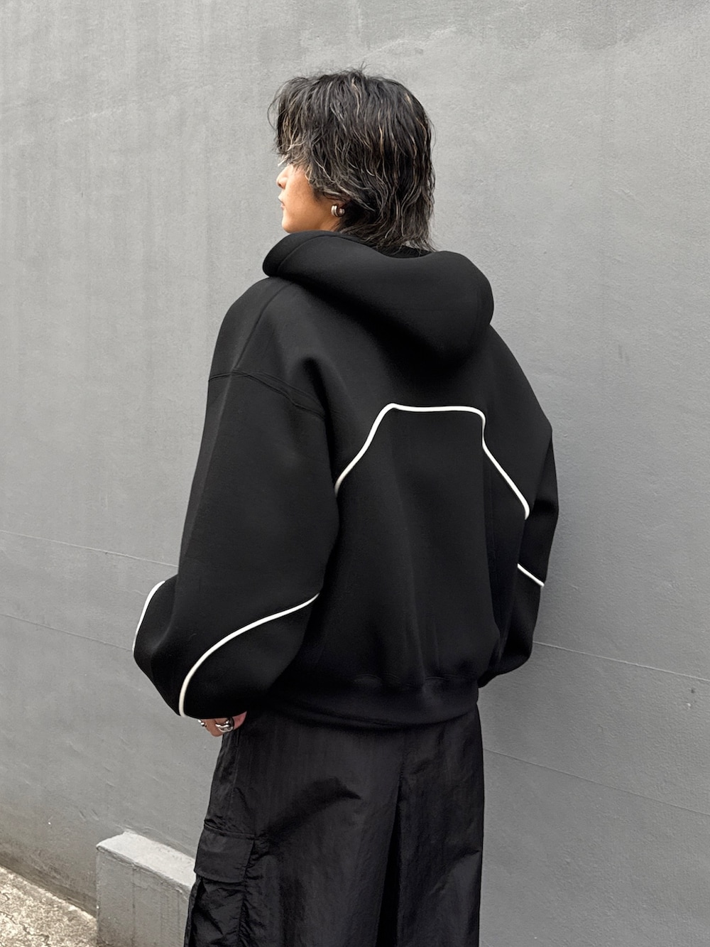 ブラック系のパーカー、ブラック系のカーゴパンツ、ブラック系のスウェットを着用したメンズの冬コーディネートの5枚目の写真