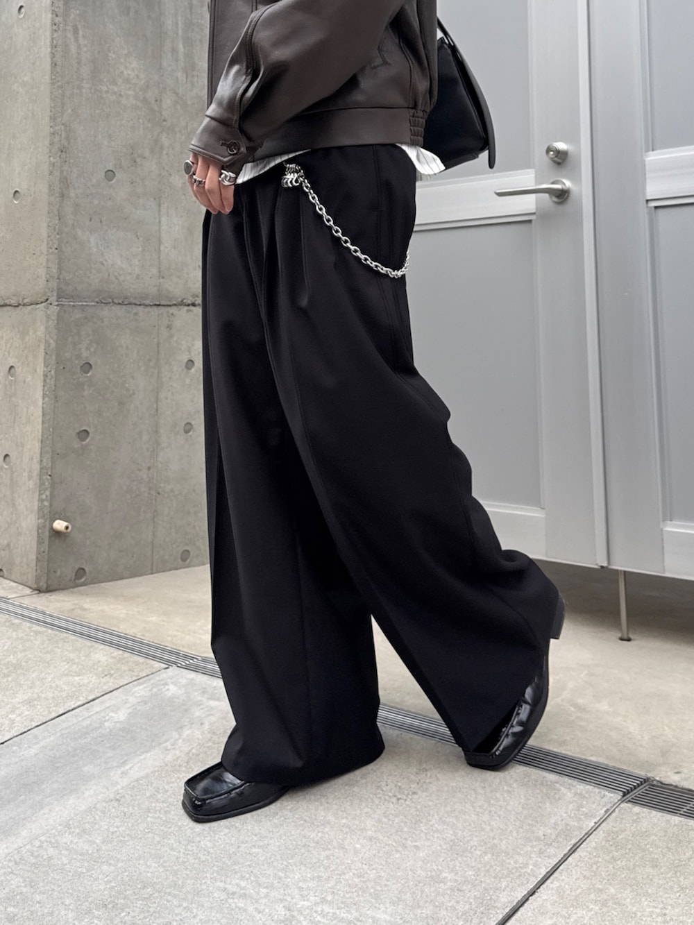 ホワイト系のシャツ/ブラウス、ブラック系のスラックス、ブラック系のショルダーバッグを着用したメンズの春コーディネートの8枚目の写真