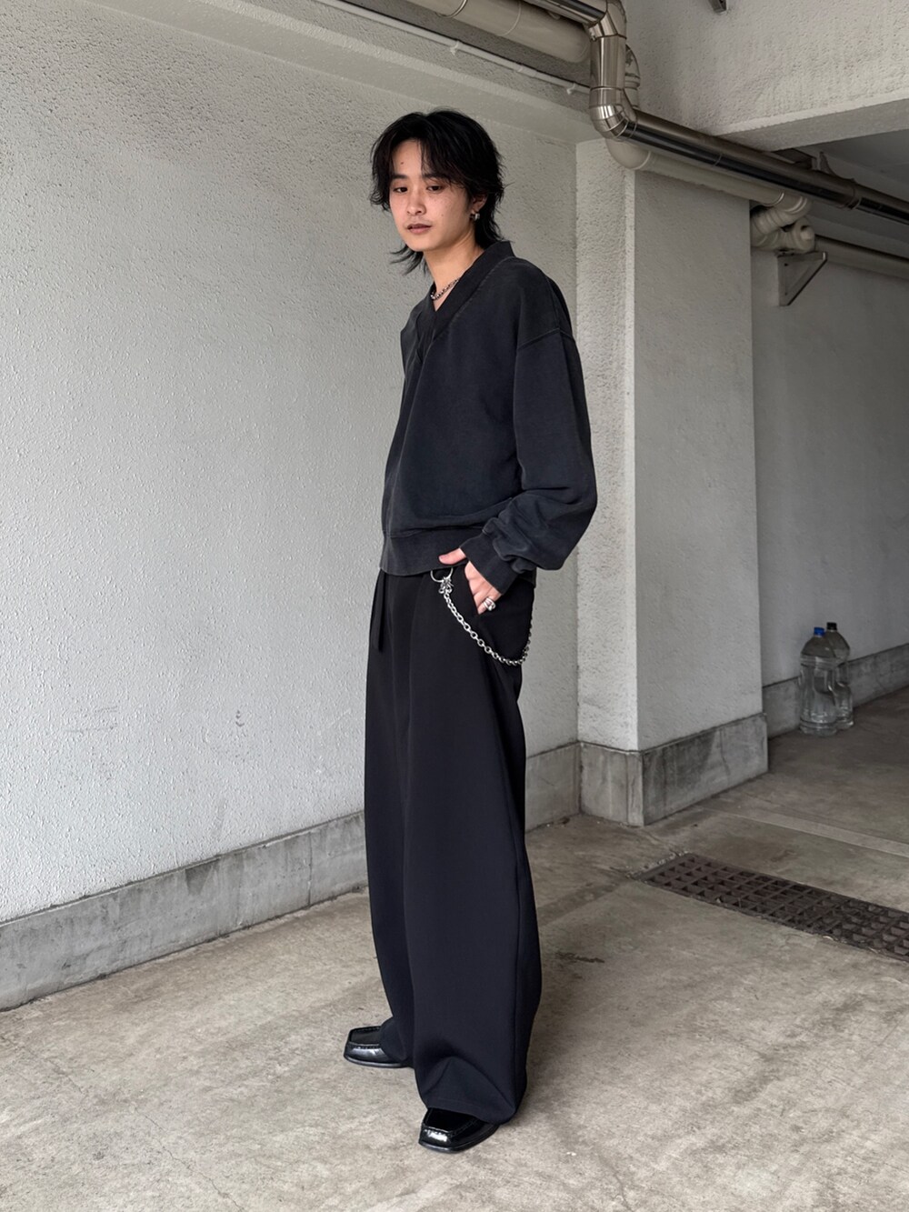 ブラック系のスウェット、ブラック系のスラックス、シルバー系のネックレスを着用したメンズの春コーディネートの2枚目の写真