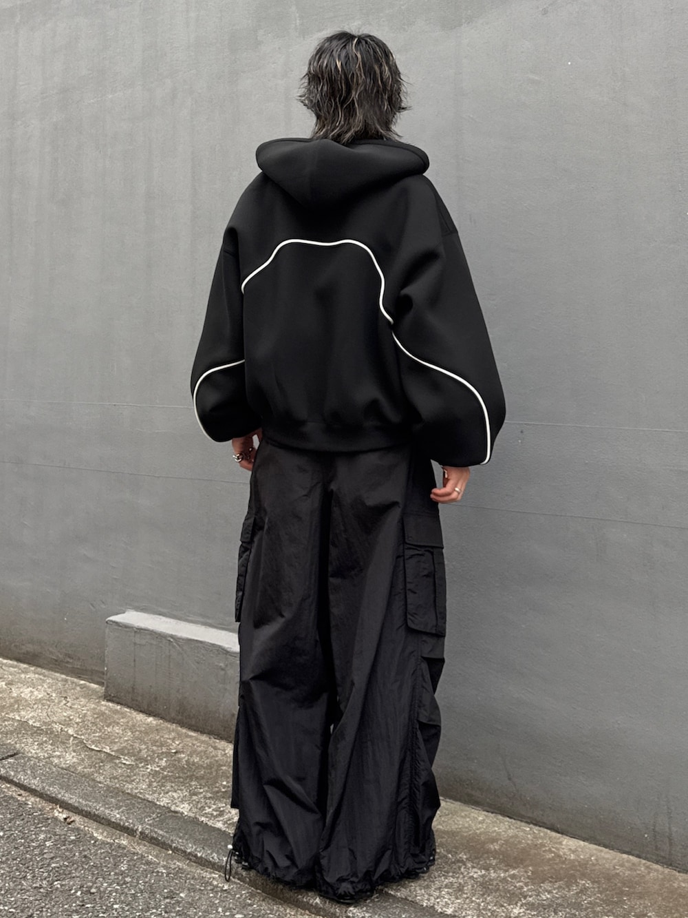 ブラック系のパーカー、ブラック系のカーゴパンツ、ブラック系のスウェットを着用したメンズの冬コーディネートの3枚目の写真