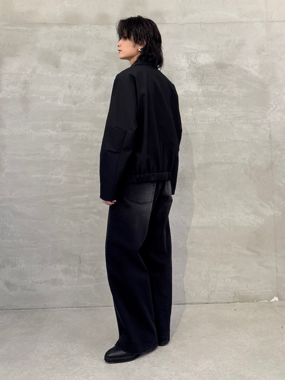 ブラック系のブルゾン、ブラック系のデニムパンツを着用したメンズの春コーディネートの2枚目の写真