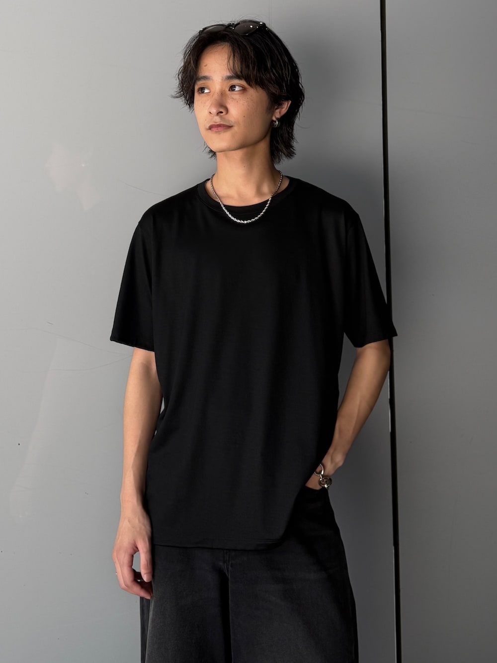 ブラック系のTシャツ/カットソー、ブラック系のデニムパンツを着用したメンズの夏コーディネートの4枚目の写真