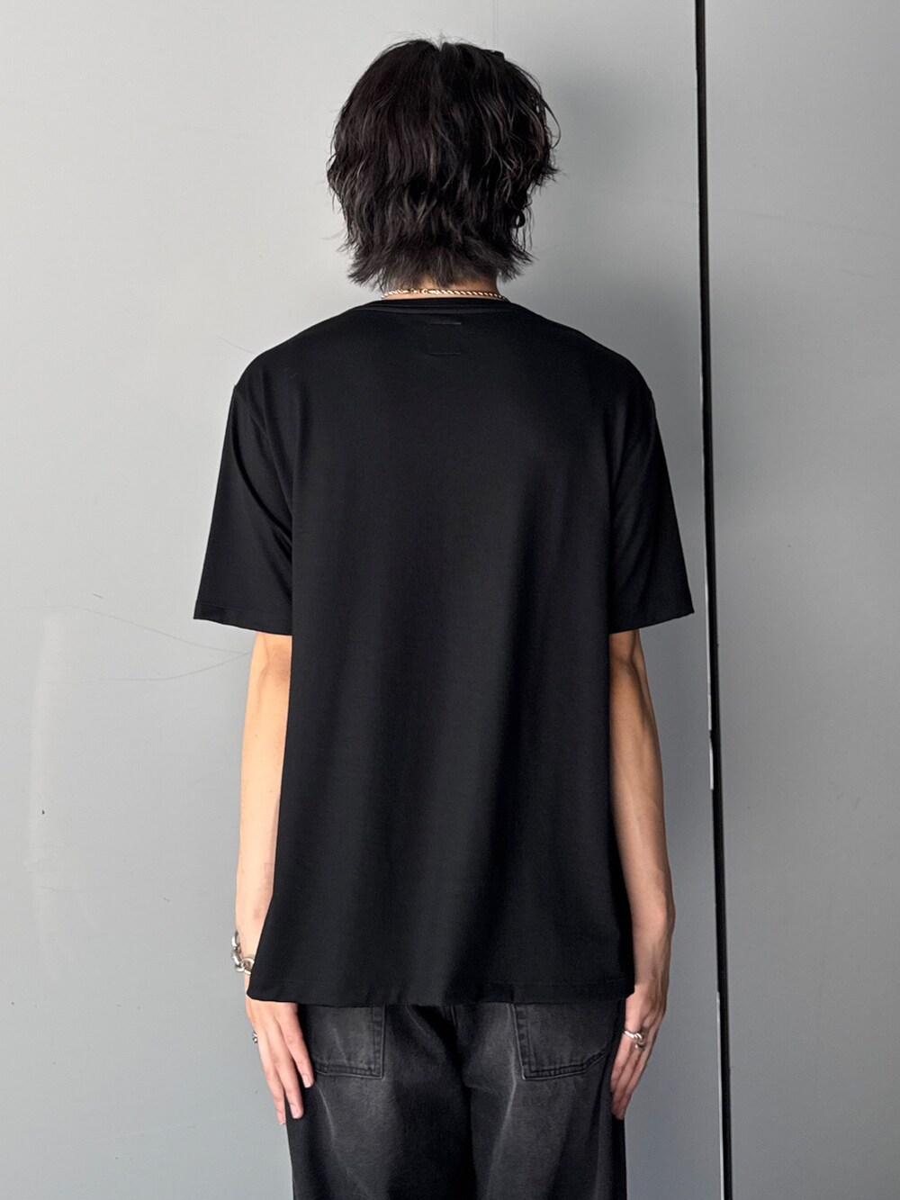 ブラック系のTシャツ/カットソー、ブラック系のデニムパンツを着用したメンズの夏コーディネートの6枚目の写真
