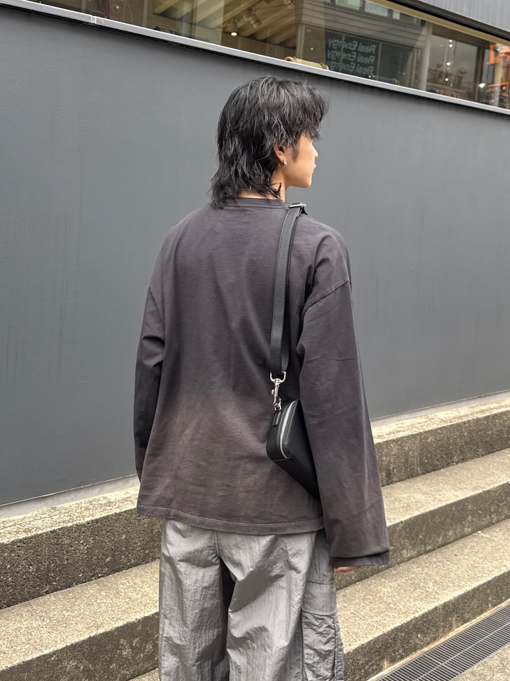 ブラック系のTシャツ/カットソー、グレー系のカーゴパンツ、ブラック系のショルダーバッグを着用したメンズの春コーディネートの6枚目の写真