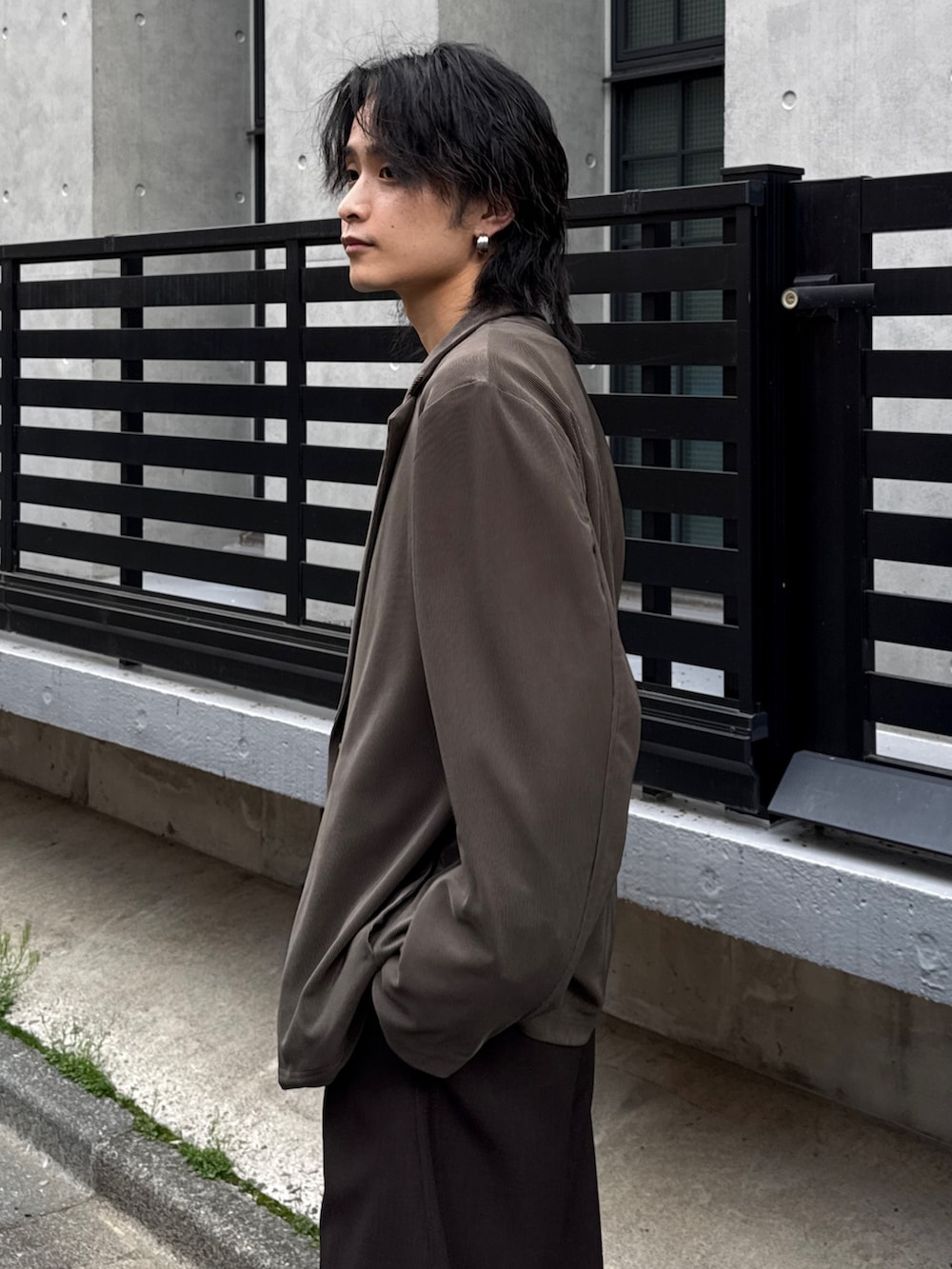 グレー系のTシャツ/カットソー、グレー系のスラックス、グリーン系のテーラードジャケットを着用したメンズの春コーディネートの5枚目の写真