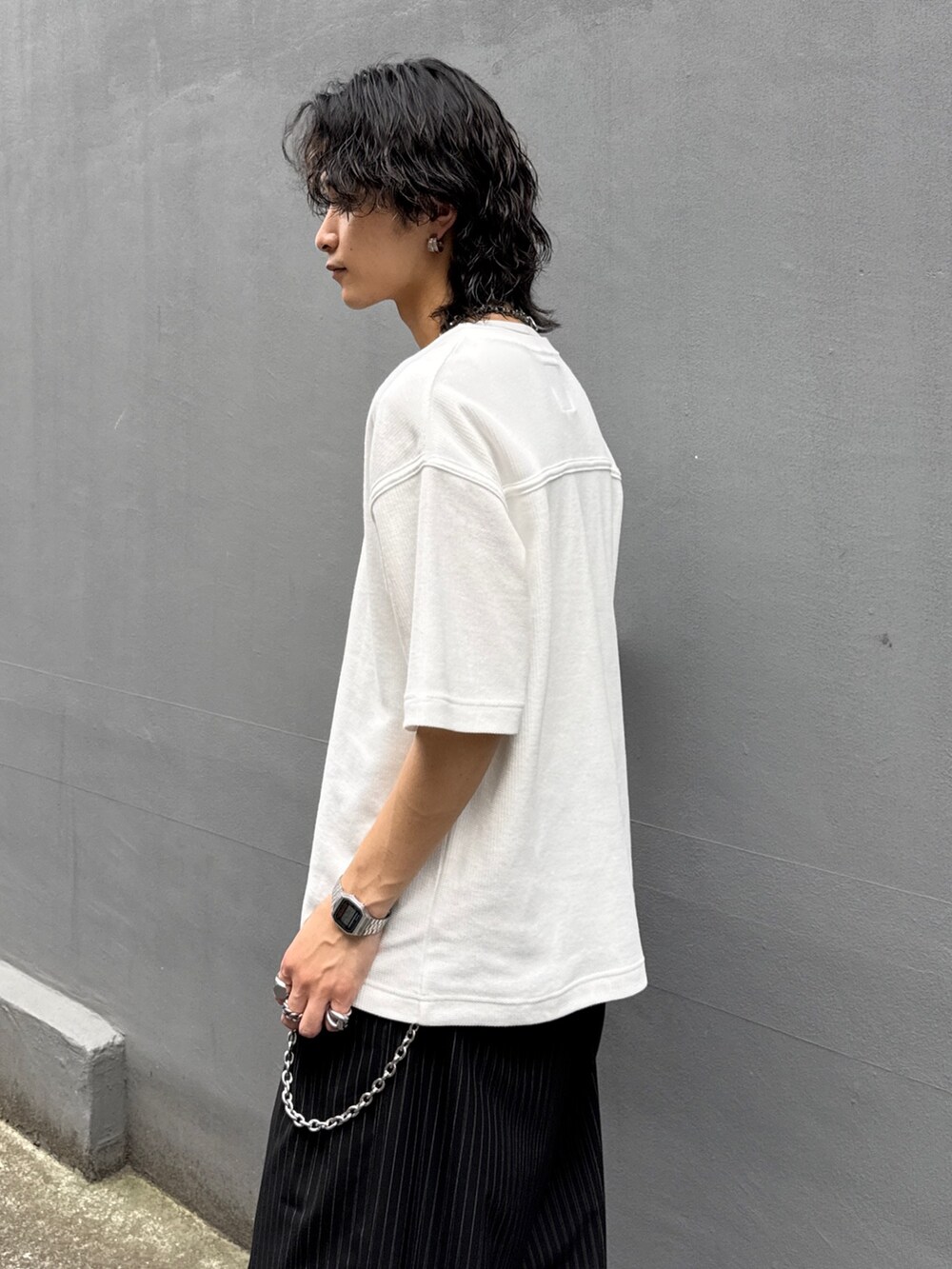 ホワイト系のTシャツ/カットソー、ブラック系のスラックス、シルバー系のウォレットチェーンを着用したメンズの夏コーディネートの5枚目の写真