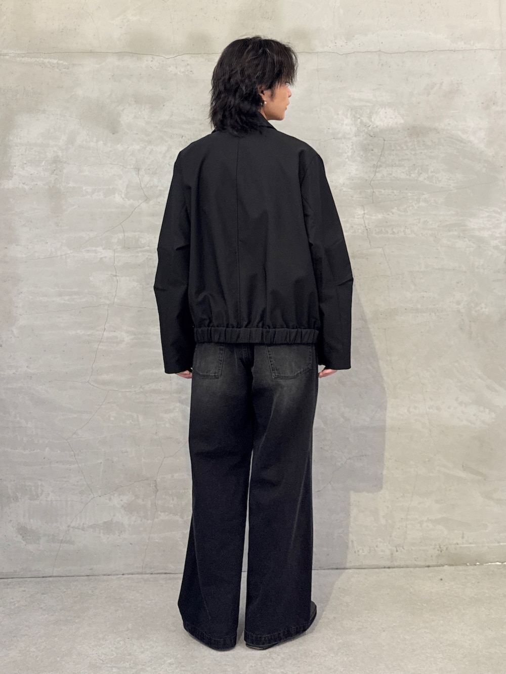 ブラック系のブルゾン、ブラック系のデニムパンツを着用したメンズの春コーディネートの3枚目の写真