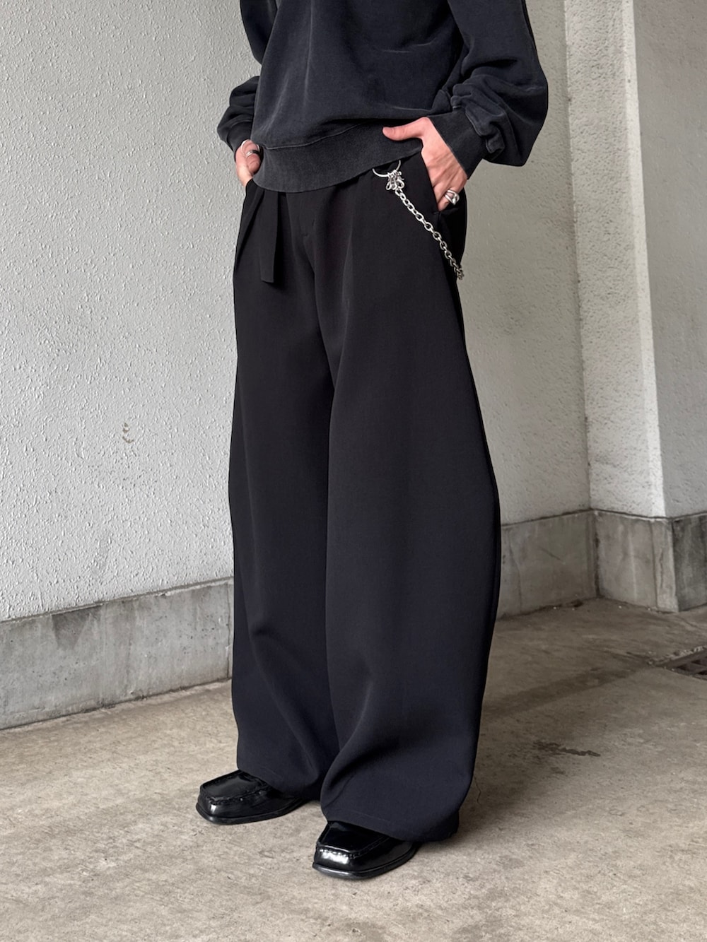 ブラック系のスウェット、ブラック系のスラックス、シルバー系のネックレスを着用したメンズの春コーディネートの8枚目の写真