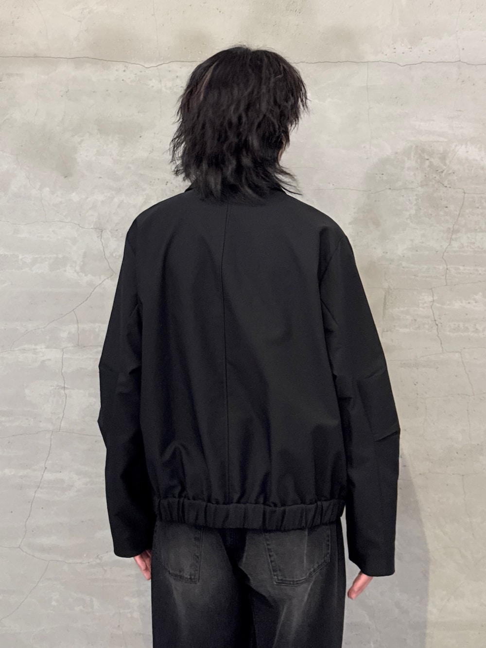 ブラック系のブルゾン、ブラック系のデニムパンツを着用したメンズの春コーディネートの6枚目の写真