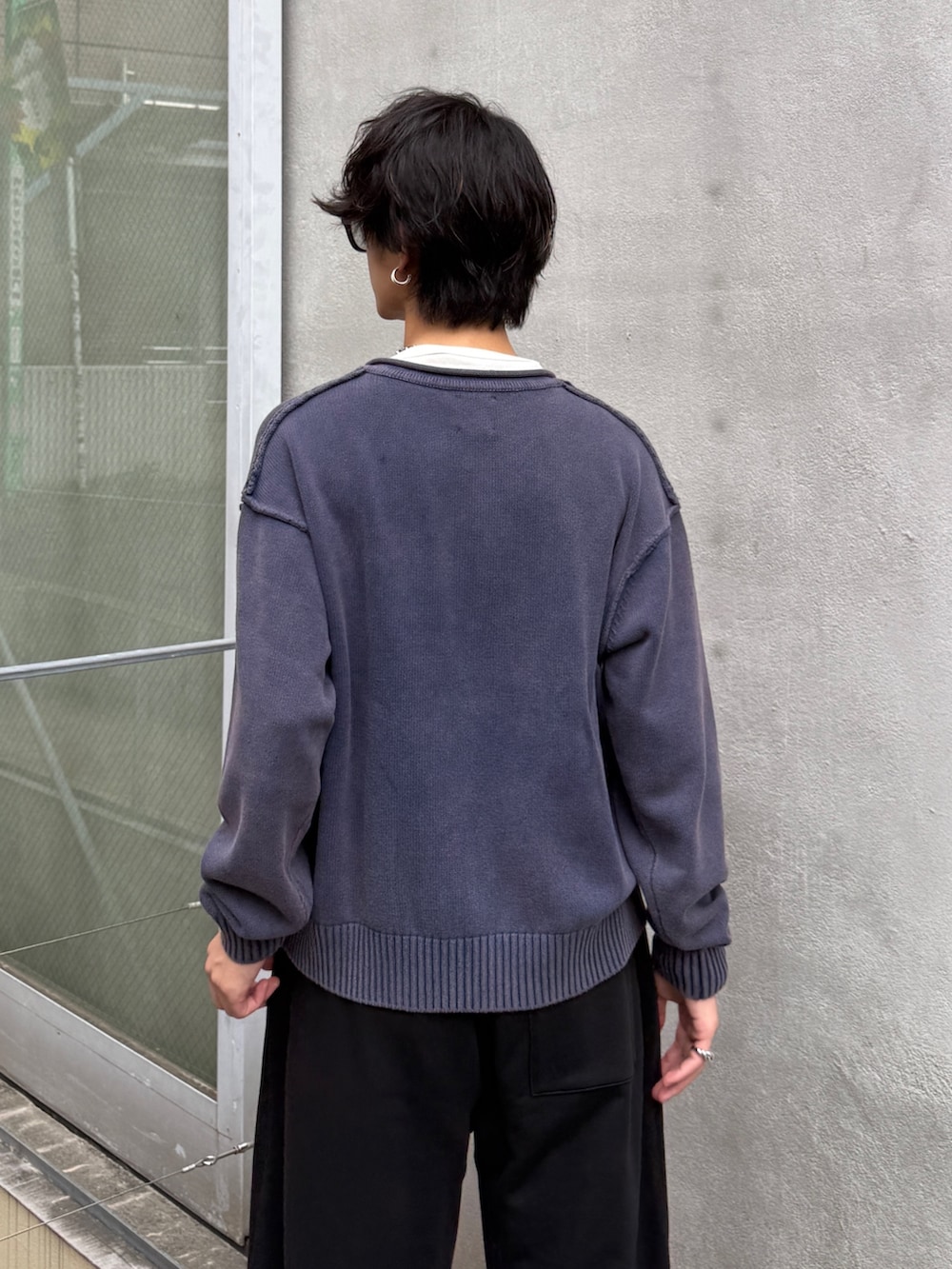 ブルー系のニット/セーター、ブラック系のスウェットパンツを着用したメンズの秋コーディネートの6枚目の写真