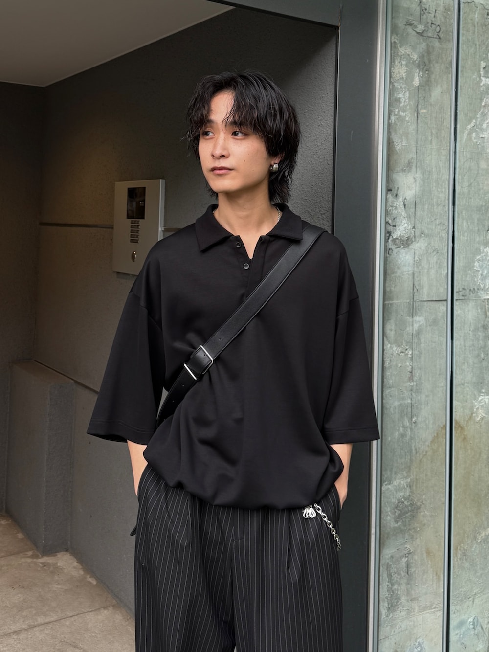 ブラック系のスラックス、ブラック系のTシャツ/カットソー、ブラック系のショルダーバッグを着用したメンズの夏コーディネートの5枚目の写真