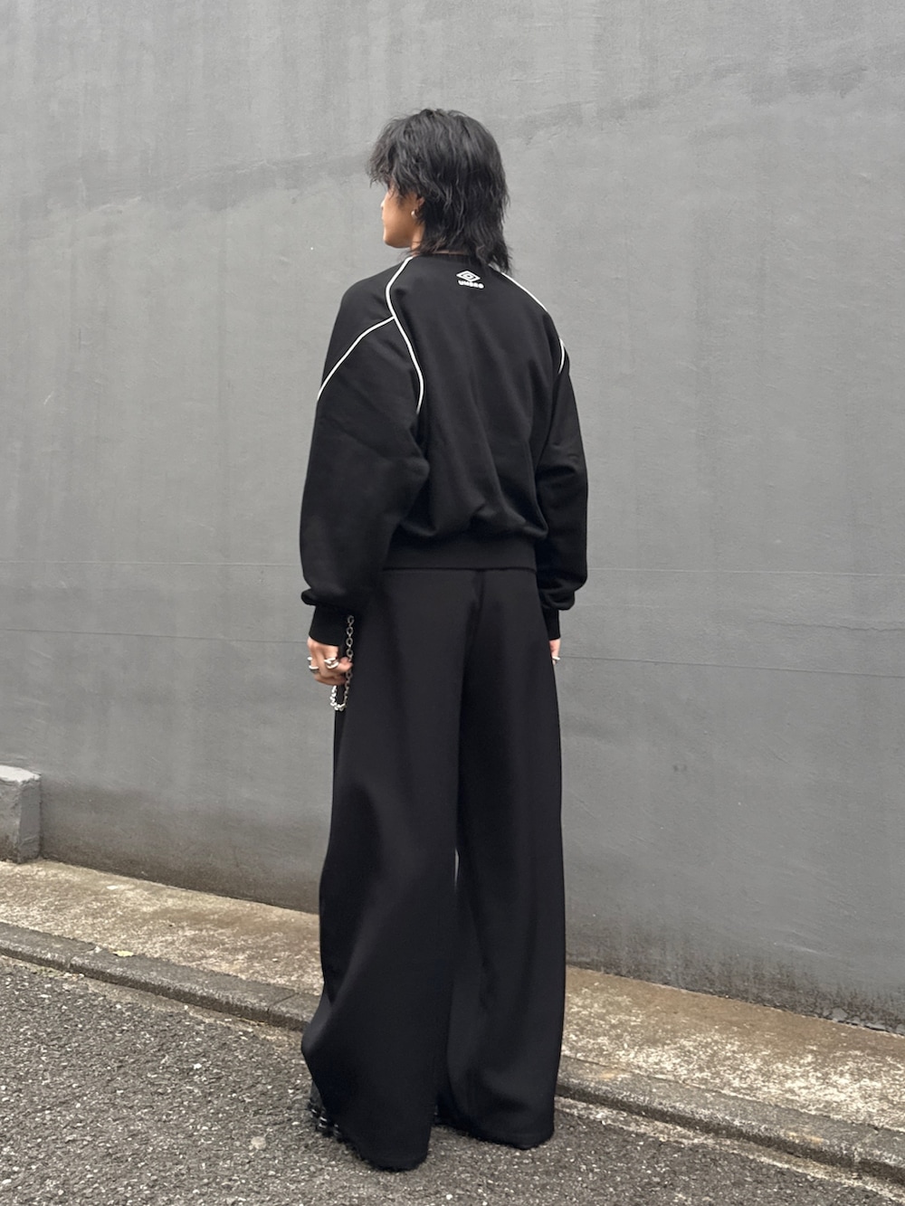 ブラック系のスウェット、ブラック系のスラックス、シルバー系のウォレットチェーンを着用したメンズの春コーディネートの2枚目の写真