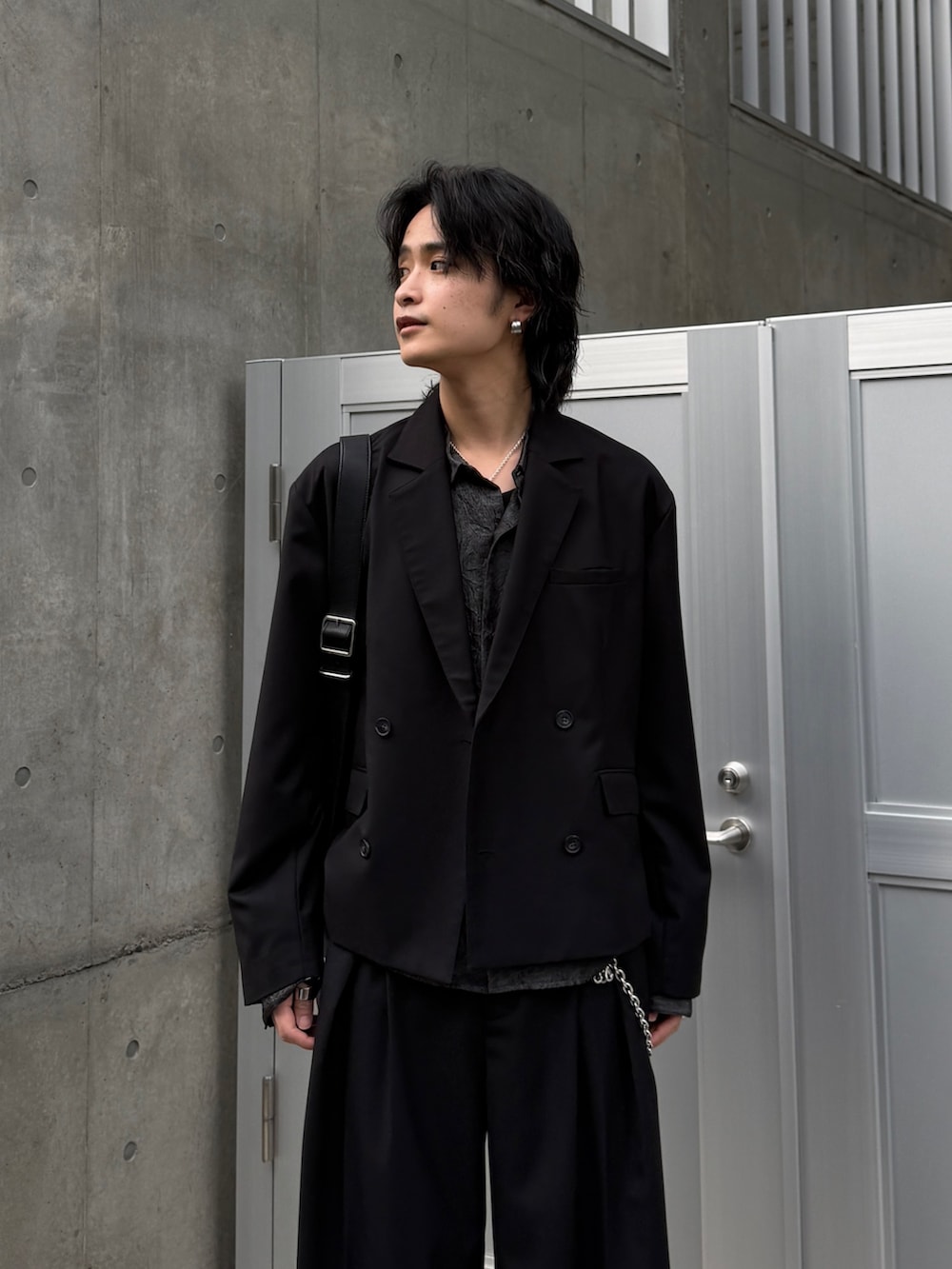 ブラック系のテーラードジャケット、ブラック系のシャツ/ブラウス、ブラック系のスラックスを着用したメンズの春コーディネートの4枚目の写真