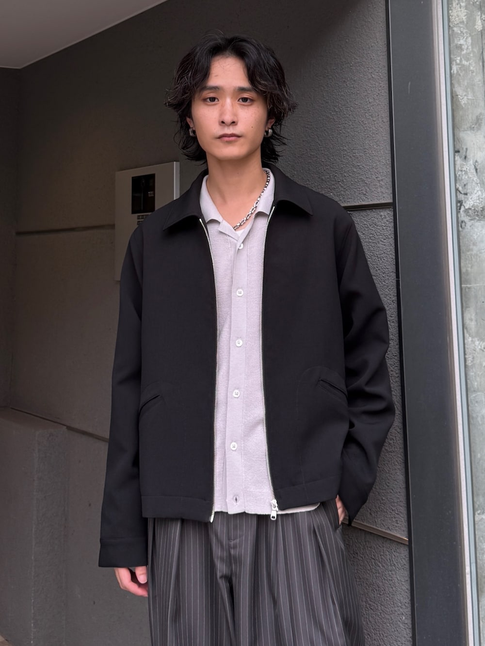 グレー系のスラックス、グレー系のシャツ/ブラウス、ブラック系のブルゾンを着用したメンズの夏コーディネートの5枚目の写真