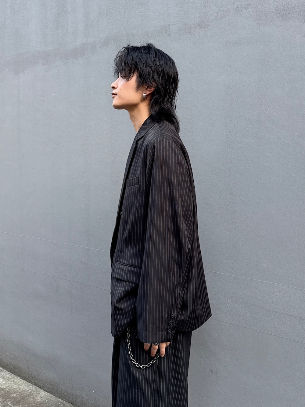 ブラック系のテーラードジャケット、ブラック系のスラックス、ホワイト系のTシャツ/カットソーを着用したメンズの春コーディネートの6枚目の写真