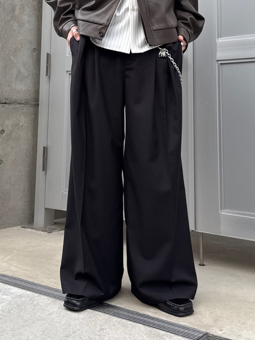 ホワイト系のシャツ/ブラウス、ブラック系のスラックス、ブラック系のショルダーバッグを着用したメンズの春コーディネートの7枚目の写真