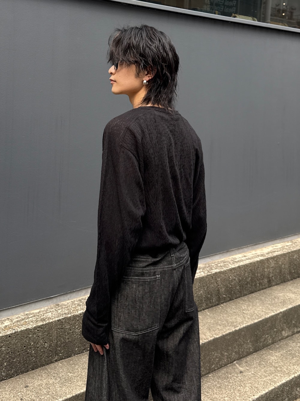 ホワイト系のブルゾン、ブラック系のTシャツ/カットソー、ブラック系のデニムパンツを着用したメンズの春コーディネートの7枚目の写真