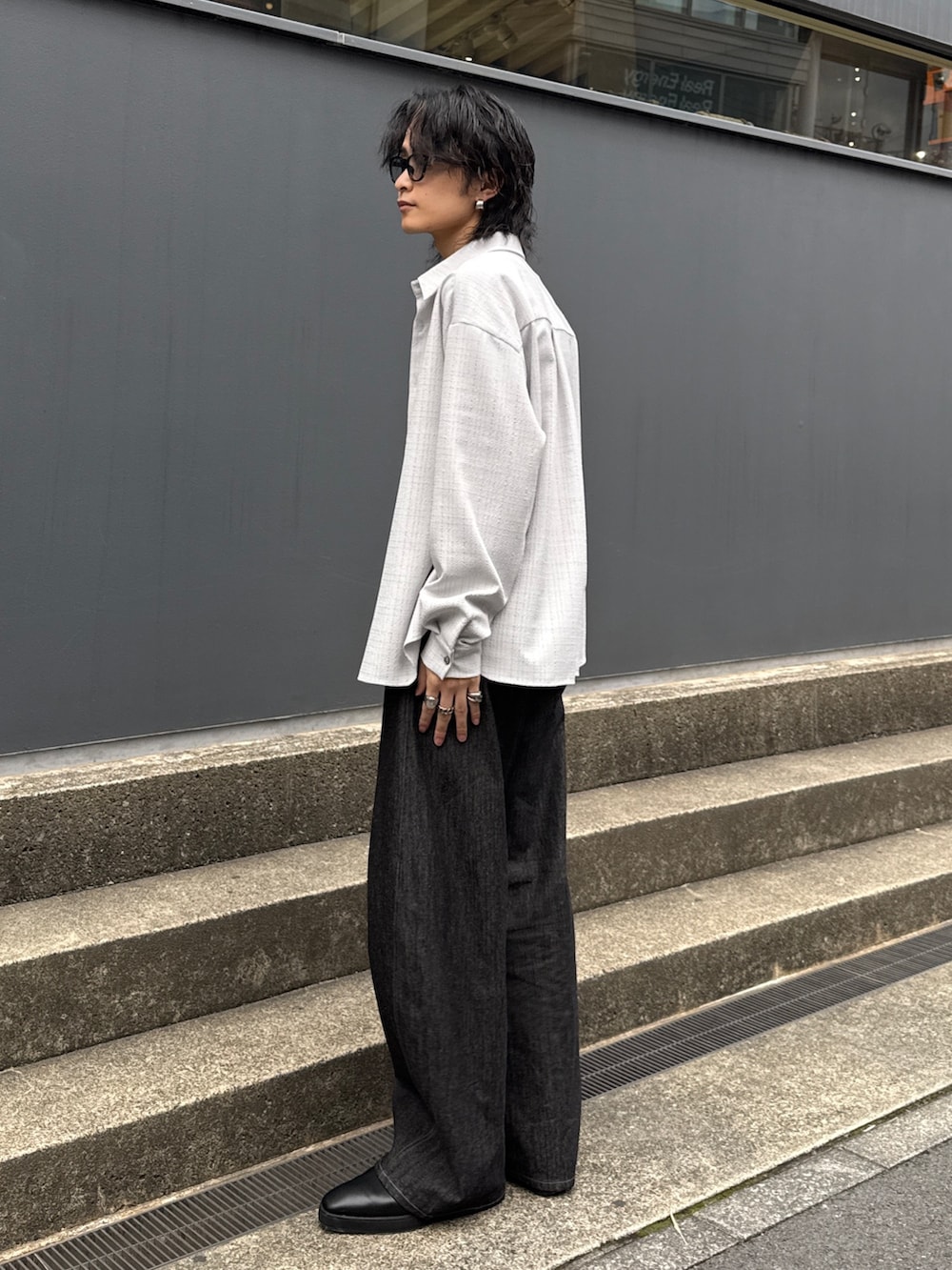 グレー系のシャツ/ブラウス、ブラック系のデニムパンツ、ブラック系のショルダーバッグを着用したメンズの春コーディネートの2枚目の写真