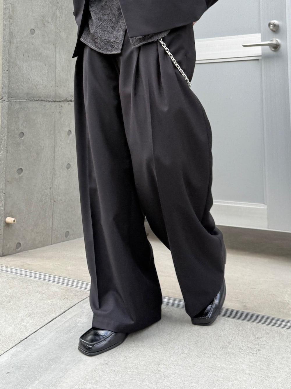 ブラック系のテーラードジャケット、ブラック系のシャツ/ブラウス、ブラック系のスラックスを着用したメンズの春コーディネートの8枚目の写真