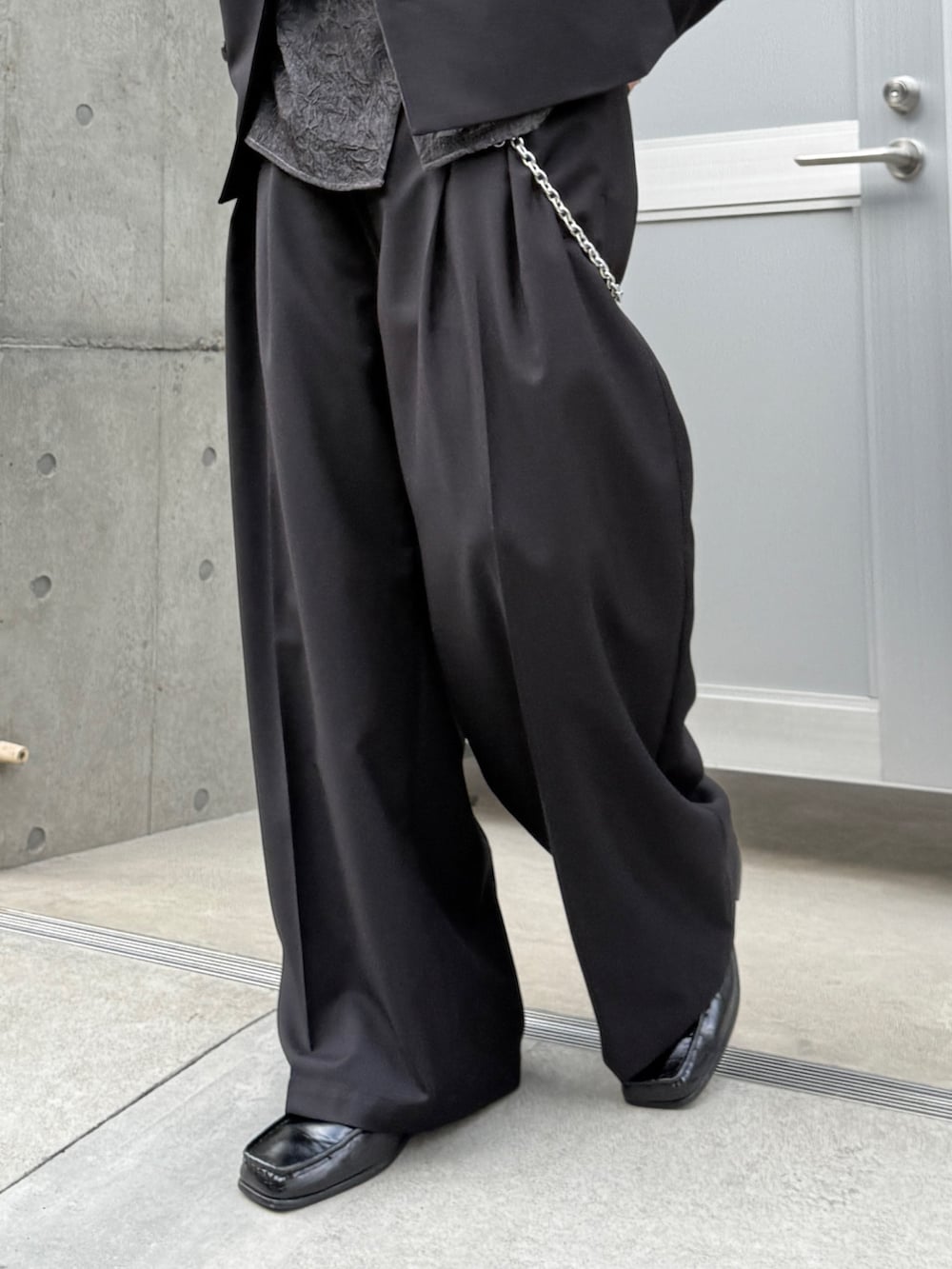 ブラック系のシャツ/ブラウス、ブラック系のスラックス、ブラック系のショルダーバッグを着用したメンズの春コーディネートの8枚目の写真