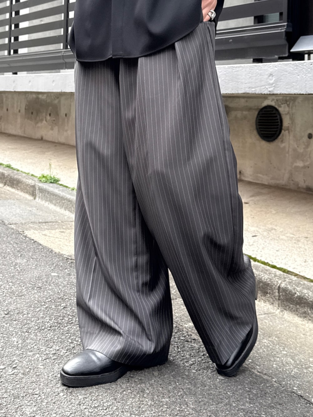 グレー系のスラックス、グレー系のテーラードジャケット、ブラック系のシャツ/ブラウスを着用したメンズの春コーディネートの9枚目の写真