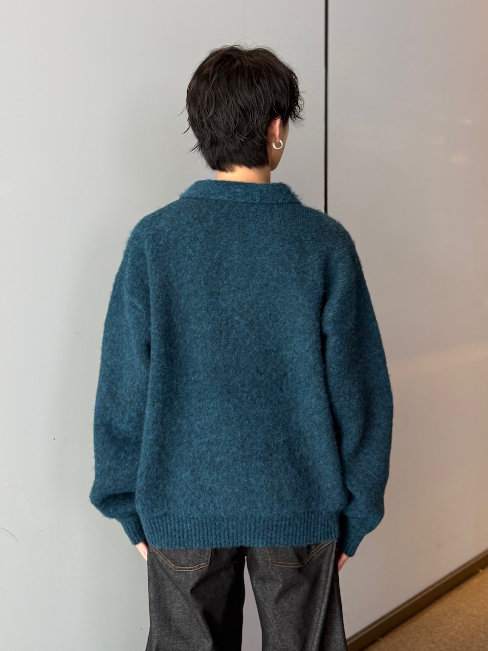 ブルー系のニット/セーター、ブラック系のデニムパンツを着用したメンズの秋コーディネートの5枚目の写真