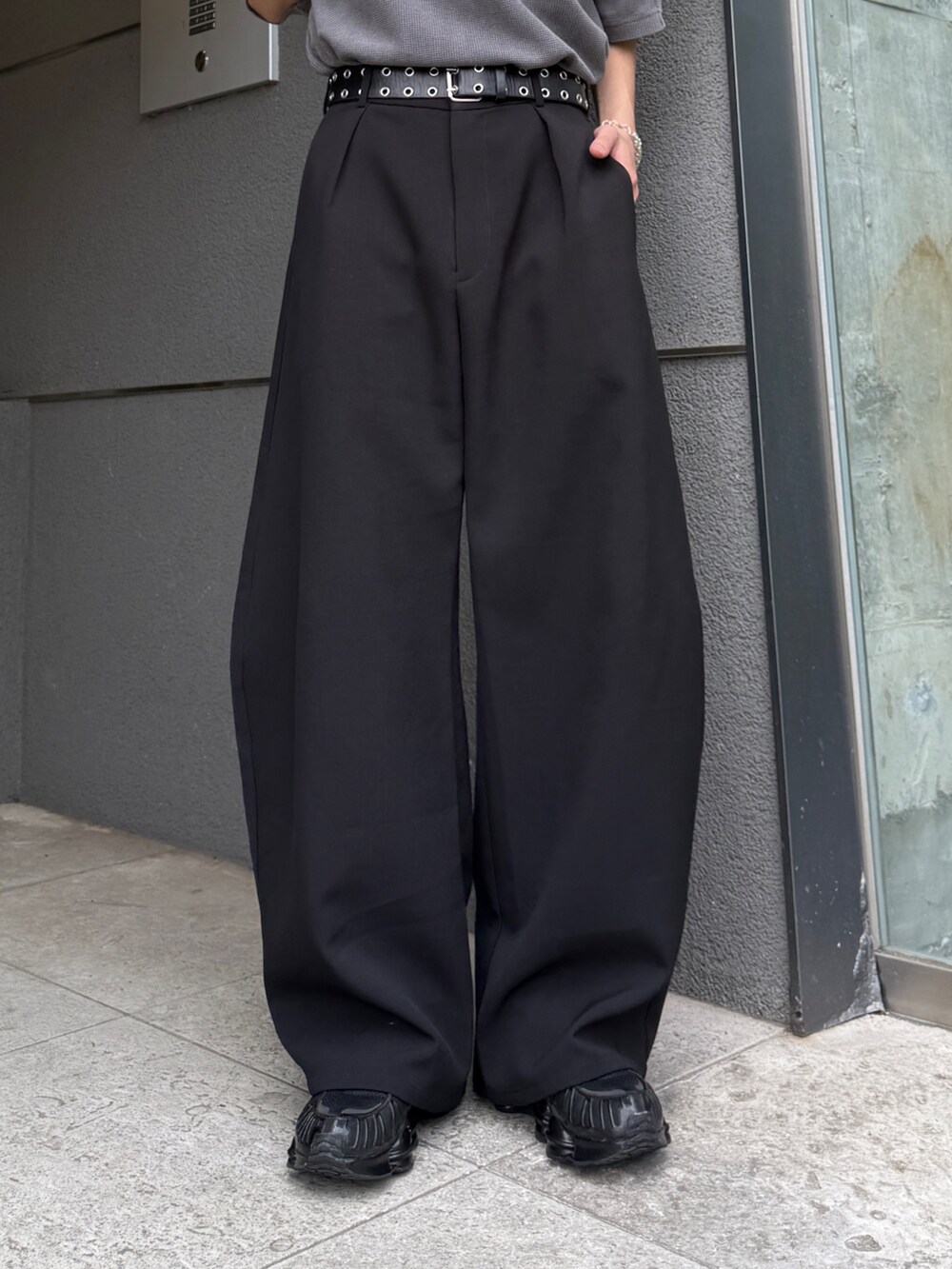 グレー系のTシャツ/カットソー、ブラック系のショルダーバッグ、ブラック系のスラックスを着用したメンズの春コーディネートの8枚目の写真