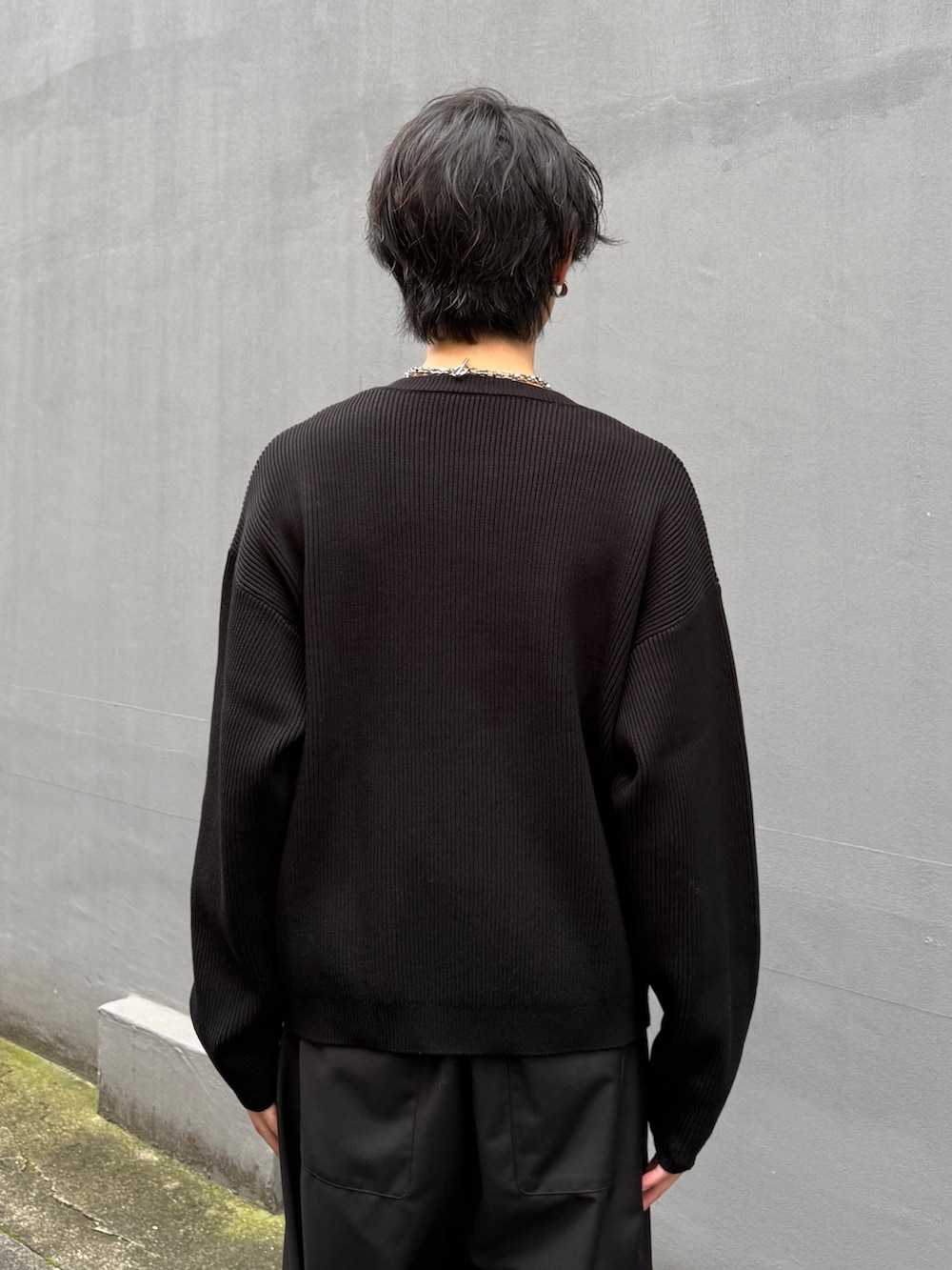 ブラック系のニット/セーター、ブラウン系のブルゾン、ブラック系のスラックスを着用したメンズの秋コーディネートの8枚目の写真